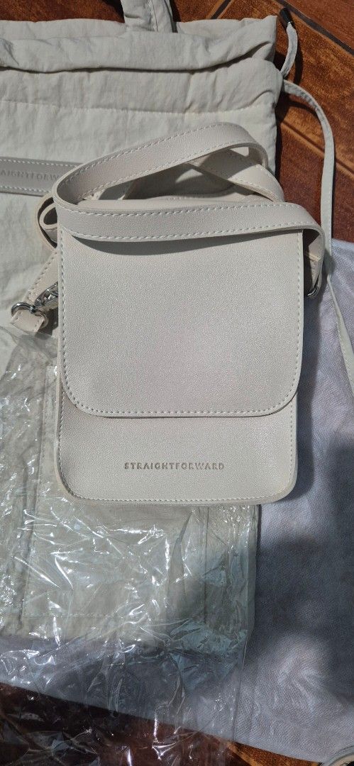 STRAIGHTFORWARD Beige Tote Bag with Matching Pouch (Category: Tote Bags) located in Las Pinas. Submitted by dressessfor_you (Listing ID 1441302687, Image 2). Description: - Stylish beige tote bag with a matching small pouch sling. - Tote features a secure drawstring closure and convenient exterior pockets. - Pouch has a flap closure with snap buttons for easy access. - Made from a lightweight, crinkled material for a unique look and feel. - Ideal