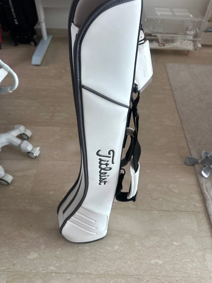Titleist Golf Bag White (Category: Golf) located in Singapore. Submitted by jashawnkong (Listing ID 1441203426, Image 3). Description: - White and black Titleist golf bag - Features prominent Titleist logo - Comes with a shoulder strap - Includes a tag - Compact design, suitable as a travel cover or smaller stand bag - Perfect for carrying golf clubs Original from MST , not fake online , used for few times .