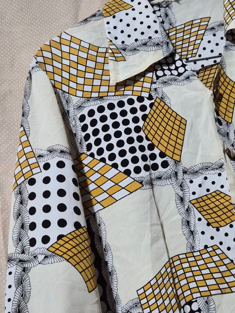 Vintage Geometric Print Button-Up Shirt (Category: Tshirts & Polo Shirts ) located in Mandaue City. Submitted by chuchi152615 (Listing ID 1441323931, Image 3). Description: - Unique retro button-up shirt - Eye-catching geometric and polka dot pattern - Cream base with black, white, and yellow accents - Long sleeves with button cuffs - Classic collar - Perfect for a statement outfit - Approximate measurements: 19 inches pit to pit.
