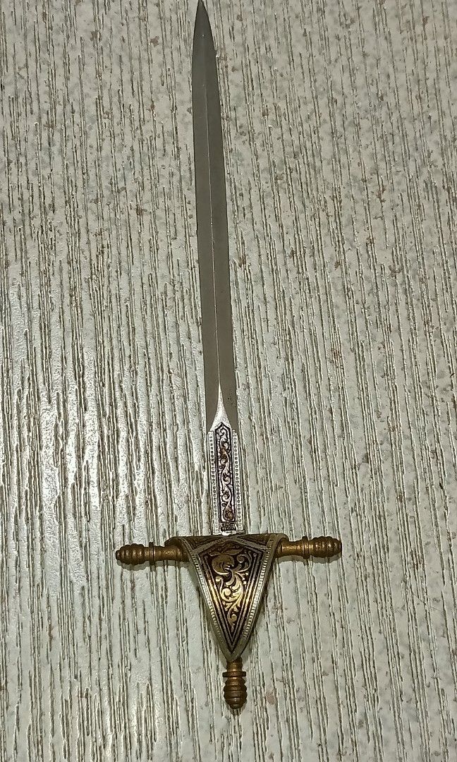 Vintage Toledo miniature sword (Category: Vintage Collectibles) located in Quezon City. Submitted by Bernz (Listing ID 1441215659, Image 1). Description: This is a decorative letter opener in the form of a vintage Spanish Toledo miniature sword, featuring an etched blade and ornate guard.Origin: Produced in Toledo, Spain, a city famous for its sword-making history.Design Details: The piece typically includes a straight, double-edged blade and a h