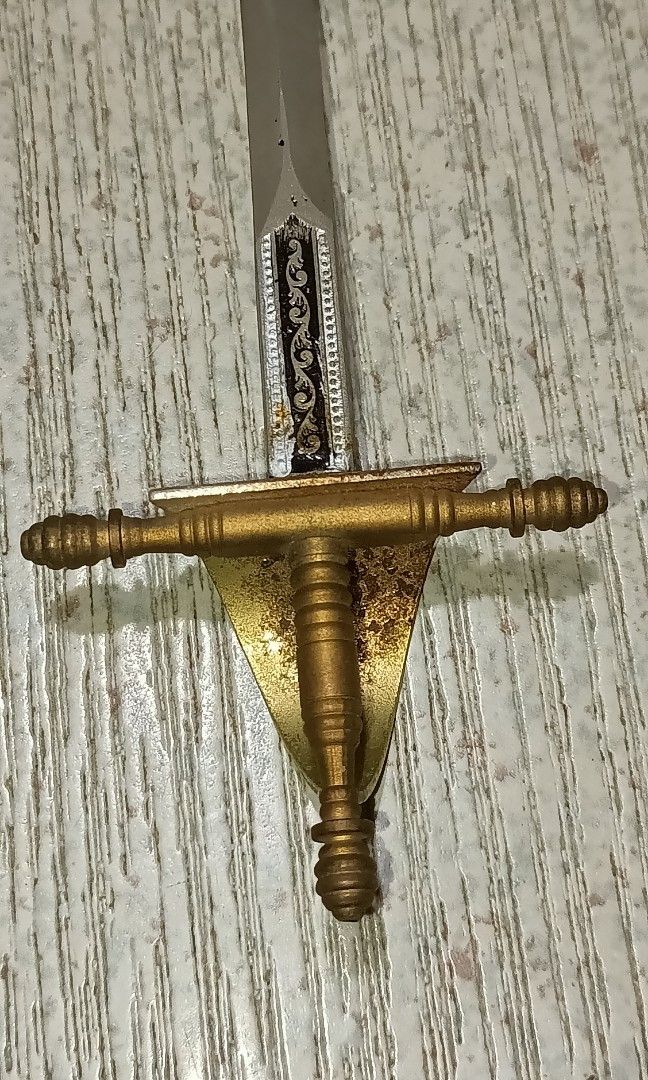 Vintage Toledo miniature sword (Category: Vintage Collectibles) located in Quezon City. Submitted by Bernz (Listing ID 1441215659, Image 3). Description: This is a decorative letter opener in the form of a vintage Spanish Toledo miniature sword, featuring an etched blade and ornate guard.Origin: Produced in Toledo, Spain, a city famous for its sword-making history.Design Details: The piece typically includes a straight, double-edged blade and a h
