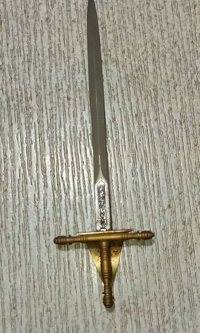 Vintage Toledo miniature sword (Category: Vintage Collectibles) located in Quezon City. Submitted by Bernz (Listing ID 1441215659, Image 2). Description: This is a decorative letter opener in the form of a vintage Spanish Toledo miniature sword, featuring an etched blade and ornate guard.Origin: Produced in Toledo, Spain, a city famous for its sword-making history.Design Details: The piece typically includes a straight, double-edged blade and a h
