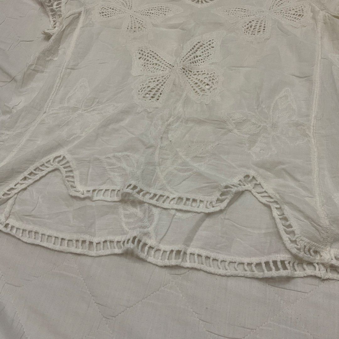 White Butterfly Embroidered V-Neck Top (Category: Sleeveless) located in Las Pinas. Submitted by jhoyiii (Listing ID 1441237748, Image 3). Description: - White short-sleeved top - Size: Medium - V-neck design - Intricate butterfly embroidery - Crochet-like hem detail - Lightweight and airy fabric - Ideal for casual outings or as a beach cover-up.