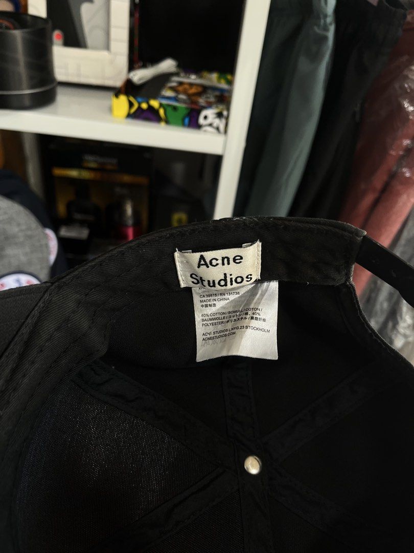 Acne Studios Black Cap with Square Face Logo (Category: Caps & Hats) located in Pinamalayan. Submitted by chay0921 (Listing ID 1443040692, Image 3). Description: - Brand: Acne Studios - Color: Black - Feature: White square logo with face graphic on front - Adjustable strap at the back for a custom fit - Material: Cotton and Polyester blend - Ideal for everyday wear - Unique side patch detail.