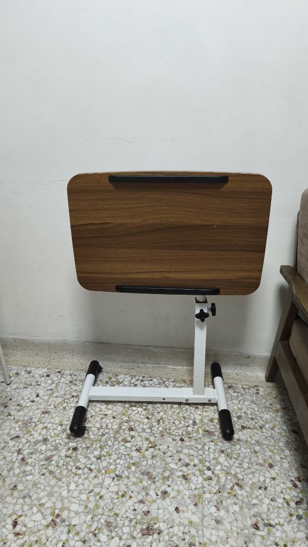 Adjustable Height Table (Category: Tables & Sets) located in Singapore. Submitted by echenen (Listing ID 1443060325, Image 2). Description: - Side table for laptop, reading, etc - Adjustable height - Adjustable angle - Wood-grain finish top - White metal base with black feet - Ideal for couch or bed use - Compact and easy to move/store - Selling cheap because of the two small cracks on the surface. (see pics).