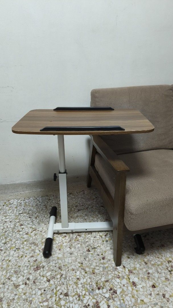 Adjustable Height Table (Category: Tables & Sets) located in Singapore. Submitted by echenen (Listing ID 1443060325, Image 1). Description: - Side table for laptop, reading, etc - Adjustable height - Adjustable angle - Wood-grain finish top - White metal base with black feet - Ideal for couch or bed use - Compact and easy to move/store - Selling cheap because of the two small cracks on the surface. (see pics).