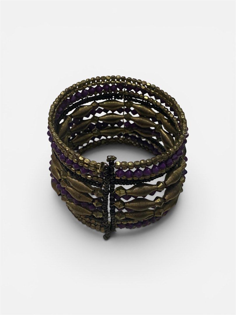 Boho Beaded Cuff Bracelet Purple and Gold Tones (Category: Bracelets) located in Gapan. Submitted by sonikku (Listing ID 1443049846, Image 3). Description: - Boho-style cuff bracelet - Features layers of purple beads - Gold-toned metal accents, some resembling springs/coils - Wide, statement piece - Adds flair to any outfit.