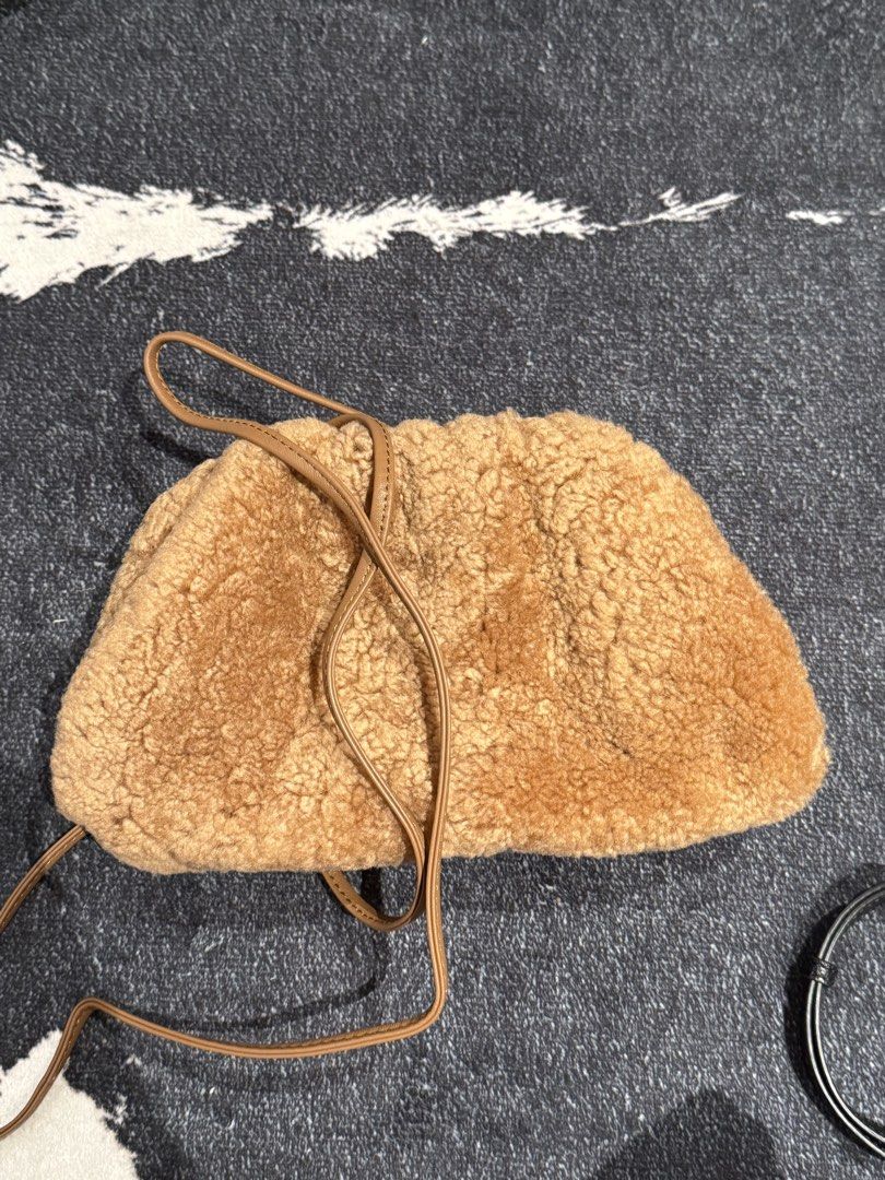 Bottega Veneta Shearling Clutch Bag (Category: Luxury Bags & Wallets) located in Caloocan City. Submitted by mightbagsph23 (Listing ID 1442997515, Image 2). Description: - Brown shearling clutch - Genuine leather strap - Bottega Veneta logo inside - Made in Italy - Gathered top closure - Spacious interior with leather lining - Ideal for evening wear or as a statement accessory.