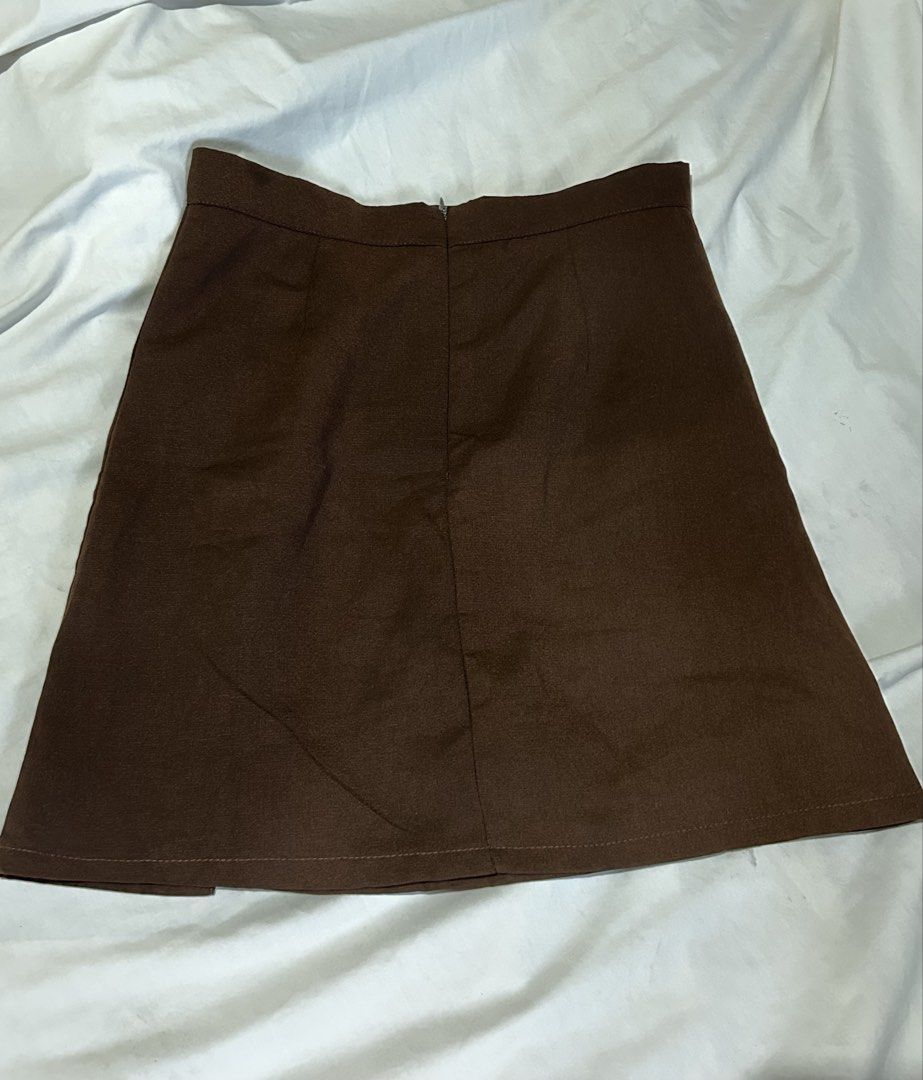 Dark Brown Mini Skirt with Side Slit [S] (Category: Skirts) located in Caloocan City. Submitted by ctrl12 (Listing ID 1443021530, Image 2). Description: - Stylish brown mini skirt - Features a trendy side slit - Convenient back zipper closure - Measurements laid flat: Waist approx. 13 inches, Length approx. 17 inches - Versatile for casual outings or dressing up - No flaws Rfs: declutterring MOP: GCash MOD: J&t, lalamove, Grabexpress.