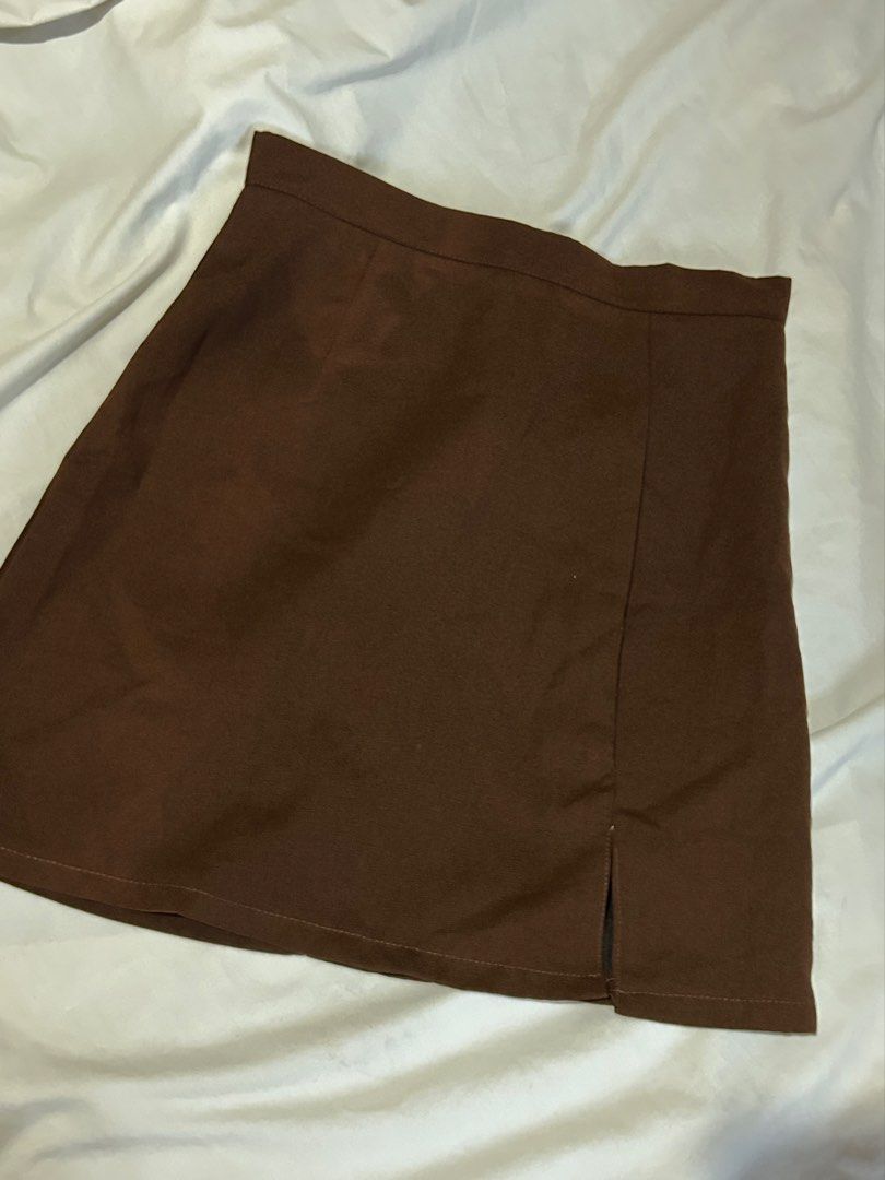Dark Brown Mini Skirt with Side Slit [S] (Category: Skirts) located in Caloocan City. Submitted by ctrl12 (Listing ID 1443021530, Image 1). Description: - Stylish brown mini skirt - Features a trendy side slit - Convenient back zipper closure - Measurements laid flat: Waist approx. 13 inches, Length approx. 17 inches - Versatile for casual outings or dressing up - No flaws Rfs: declutterring MOP: GCash MOD: J&t, lalamove, Grabexpress.