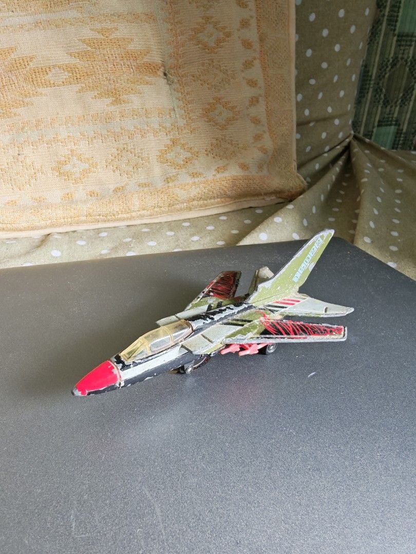 Diecast Toy Jet Fighter Plane with Missiles (Category: Vehicle & Diecast Models) located in Carmona. Submitted by tech_hub_cavite (Listing ID 1442975450, Image 3). Description: - Diecast toy jet fighter - Black and green body with red accents - Four small missiles attached to the wings - Functional wheels - Visible paint wear on the body - Ideal for collectors or play.