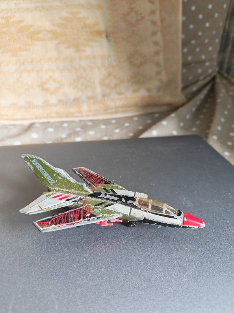 Diecast Toy Jet Fighter Plane with Missiles (Category: Vehicle & Diecast Models) located in Carmona. Submitted by tech_hub_cavite (Listing ID 1442975450, Image 2). Description: - Diecast toy jet fighter - Black and green body with red accents - Four small missiles attached to the wings - Functional wheels - Visible paint wear on the body - Ideal for collectors or play.