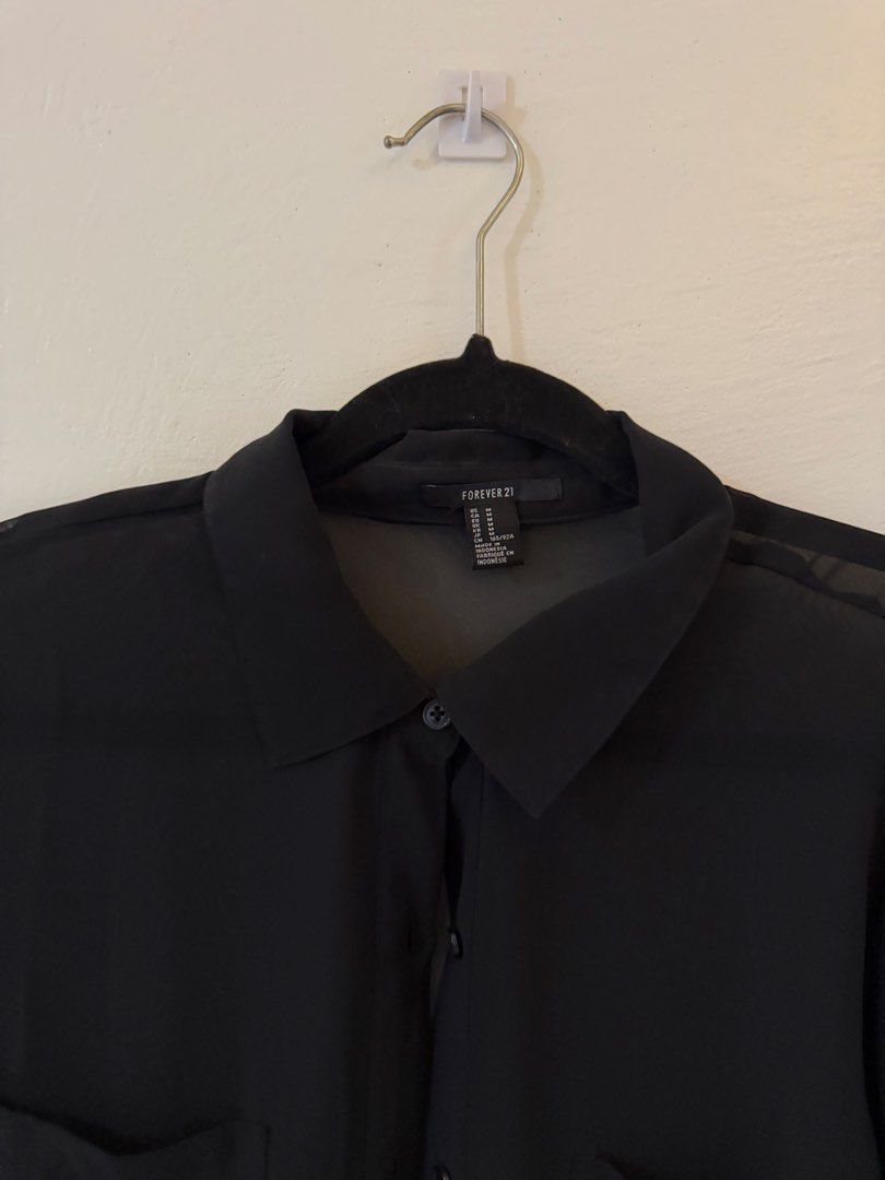 Forever 21 Black Sheer Button-Up Shirt (Category: Shirts) located in Bacoor. Submitted by conclaseph (Listing ID 1442948122, Image 2). Description: - Sheer black button-up shirt from Forever 21 - Long sleeves with button cuffs - Two chest pockets - Classic collar - Lightweight and flowy material - Ideal for layering over camis or bralettes.
