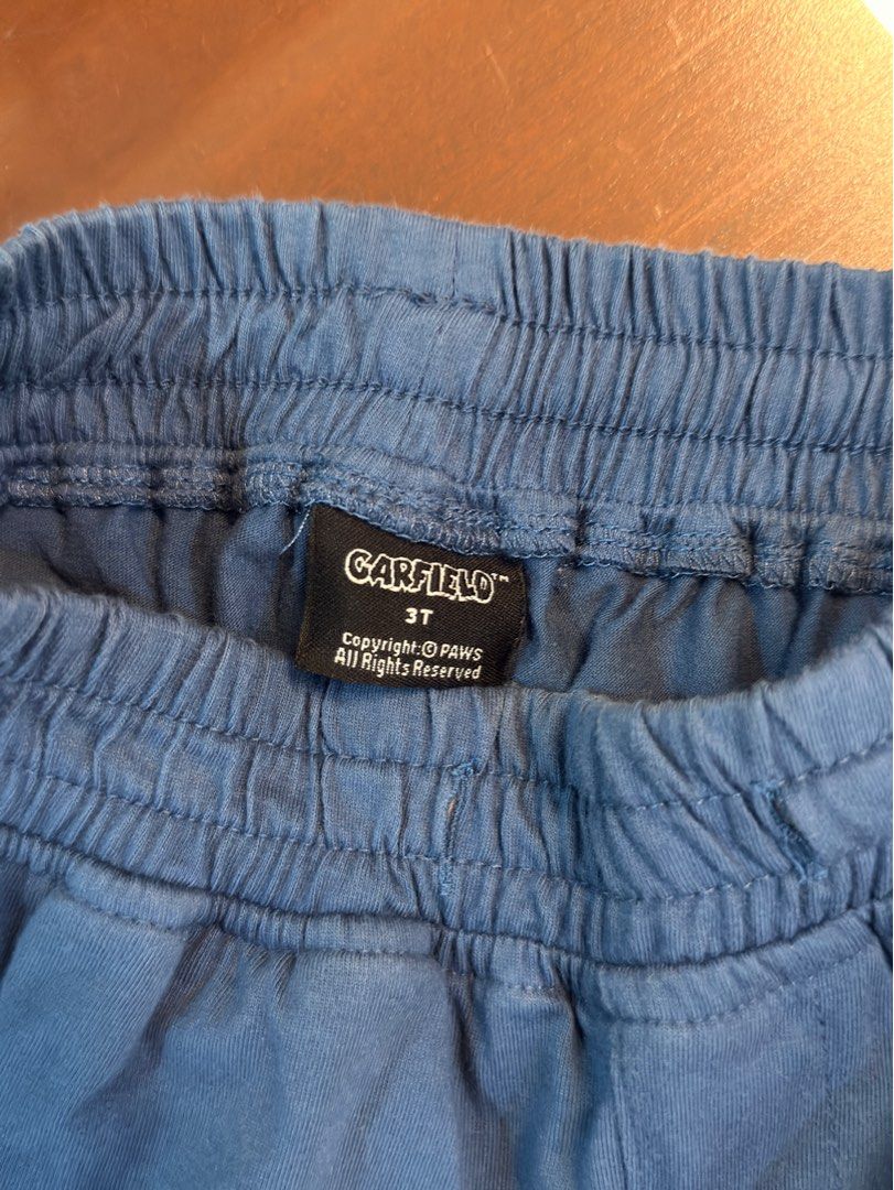 Garfield Kids Joggers Size 3T Blue (Category: Babies & Kids Fashion) located in Urdaneta. Submitted by glamduck (Listing ID 1443007725, Image 2). Description: - Adorable blue joggers featuring a cute Garfield logo on the leg. - Designed for comfort with an elastic waistband. - Perfect for active kids, ideal for everyday wear and playtime. - Size: 3T.