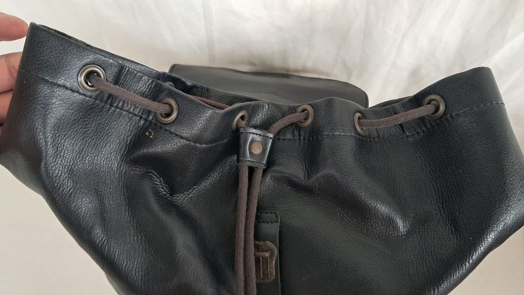 Japan Black Faux Leather Drawstring Backpack with Flap Closure (Category: Backpacks) located in Bulacan. Submitted by amarijapansurplus (Listing ID 1443019411, Image 3). Description: - Stylish black faux leather backpack - Secure drawstring closure hidden under a flap - Convenient front pocket with button closure - Adjustable straps for a comfortable fit - Ample interior space for all your essentials - Ideal for everyday use and daily commutes - 