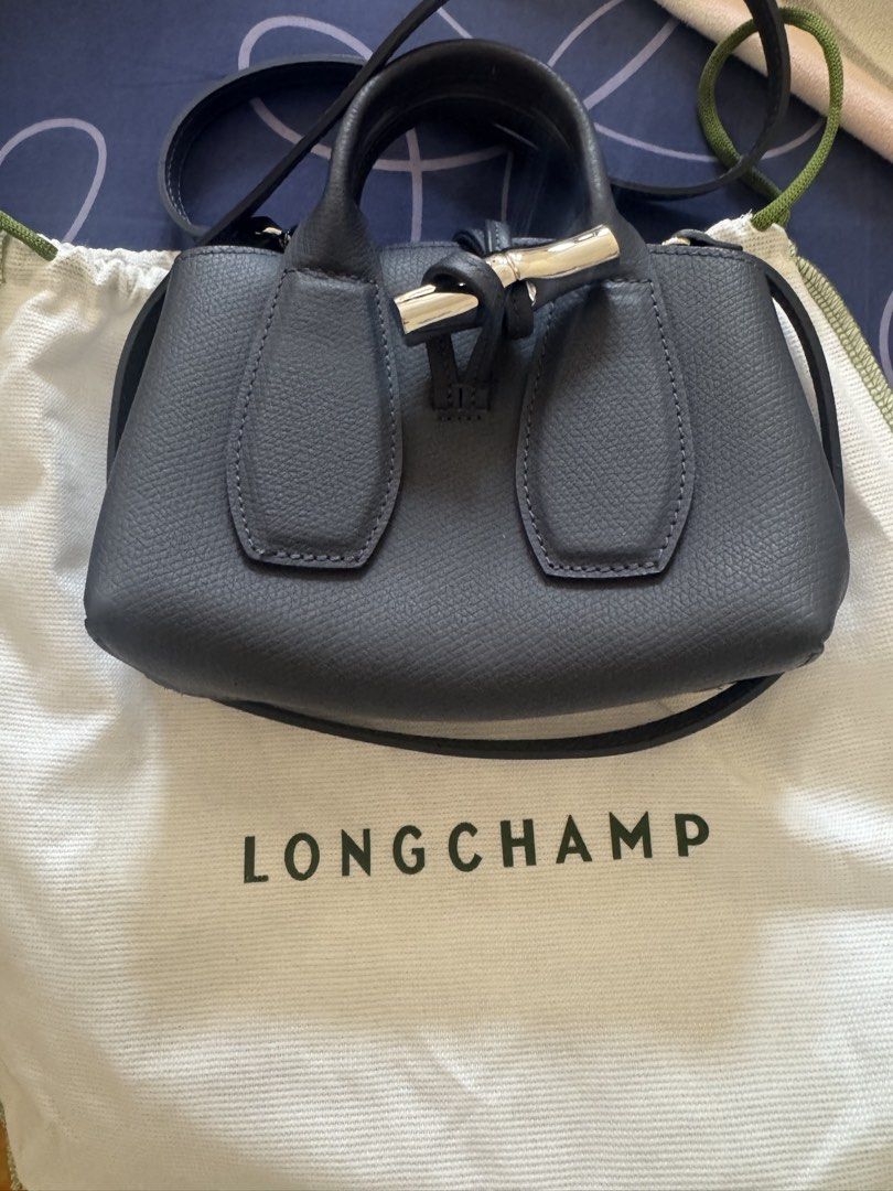 Longchamp Roseau XS Top Handle Bag (Category: Luxury Bags & Wallets) located in Valenzuela. Submitted by meme_md (Listing ID 1443038155, Image 2). Description: - Dark grey Longchamp bag - Small size, perfect for essentials - Detachable strap for crossbody wear - Features a nice leather texture - Comes with original dust bag - Very practical and stylish.