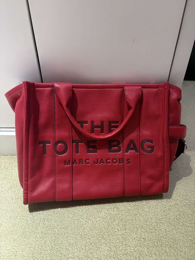Marc Jacobs The Tote Bag Red Leather (Category: Luxury Bags & Wallets) located in Quezon. Submitted by squishymallows (Listing ID 1442967627, Image 1). Description: Selling a red Marc Jacobs tote bag. It's the classic 'The Tote Bag' model. Made from leather. Plenty of space inside for all your essentials. Has an inner zip pocket and a patch pocket. Great for everyday use or travel. - signs of use and unnoticeable leather crackings.