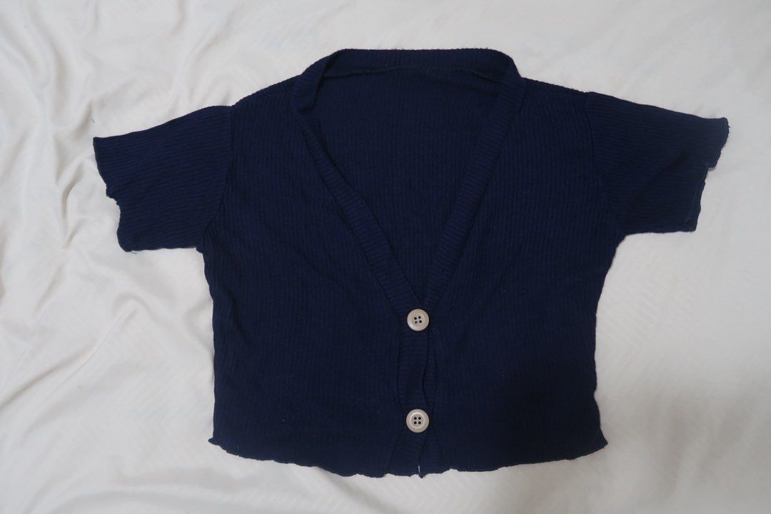 Navy Blue Ribbed Cropped Cardigan with Buttons (Category: Coats, Jackets and Outerwear) located in Legazpi City. Submitted by theaslzr (Listing ID 1443013749, Image 1). Description: - Cute navy blue cropped cardigan - Ribbed knit fabric - Short sleeves - Two button front closures - Lettuce edge detail on the hem - Can be worn open or buttoned up - Highly versatile for various styling options.