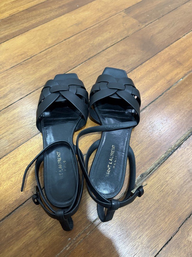 Saint Laurent Black Leather Tribute Flat Sandals (Category: Flats & Sandals) located in Taguig. Submitted by onein.oneout_declutter (Listing ID 1443120838, Image 2). Description: - Authentic Black Leather Saint Laurent Tribute Flat Sandals - Features iconic woven strap detail across the front - Adjustable ankle strap with buckle closure for a secure fit - Classic YSL design, versatile for dressing up or down.