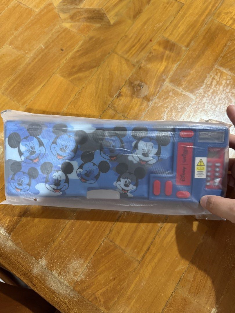 Smiggle Disney Mickey Mouse Pencil Case (Category: Stationery & School Supplies) located in Manila. Submitted by preloved_new_forsale (Listing ID 1442999206, Image 1). Description: - Cool Mickey Mouse pencil case - Blue camouflage design with all-over Mickey face print - Includes a built-in calculator and other side buttons - Ideal for school supplies or desk organization - Comes in original packaging, brand new.