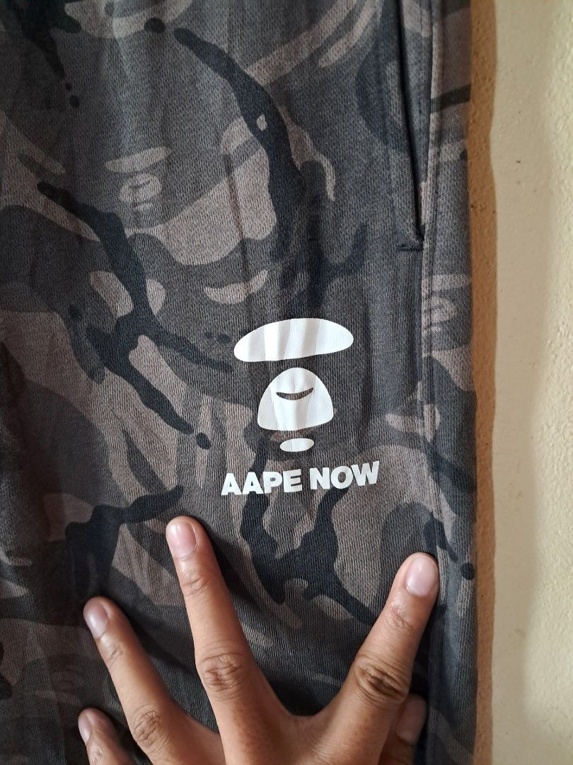 AAPE BY A BATHING APE Camo Jogger Pants (Category: Joggers) located in Silang. Submitted by segundalifestyle (Listing ID 1443265243, Image 2). Description: - Camo joggers from AAPE BY A BATHING APE - Signature ape head logo on left leg - Smaller logo detail on right pocket - removable patch logo - Drawstring waist for adjustable fit - Elasticated cuffs - Ideal for casual wear - waist 26 - Length 37.