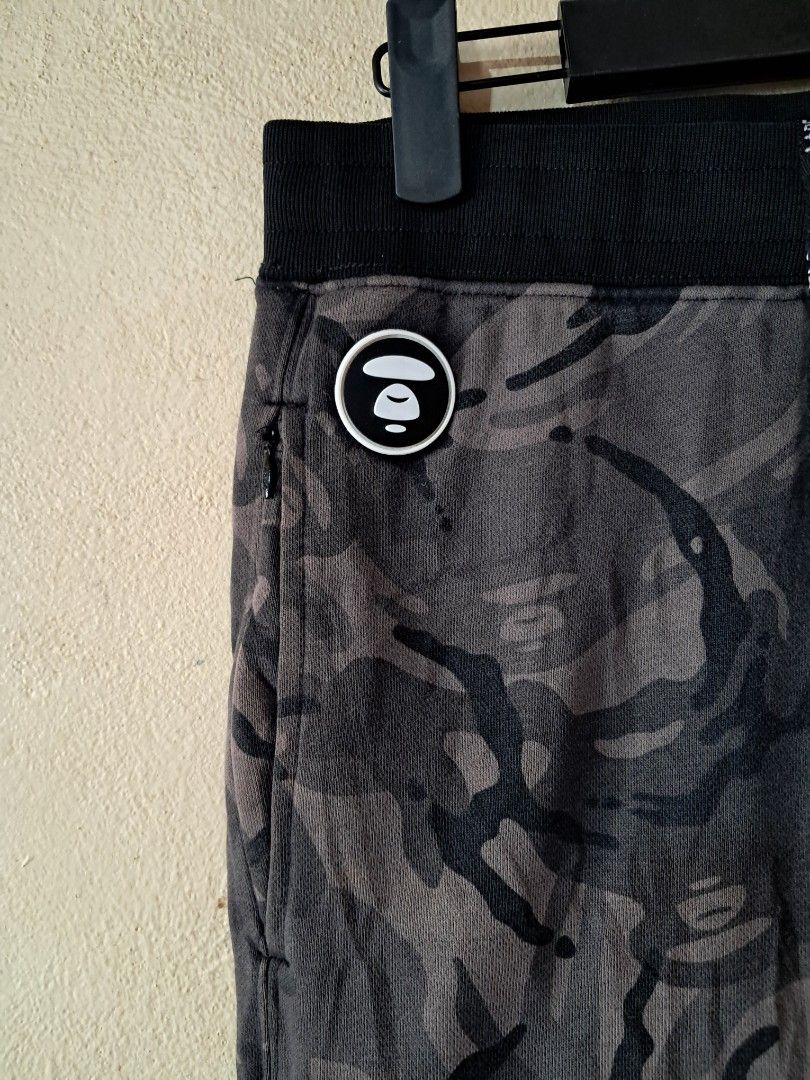 AAPE BY A BATHING APE Camo Jogger Pants (Category: Joggers) located in Silang. Submitted by segundalifestyle (Listing ID 1443265243, Image 3). Description: - Camo joggers from AAPE BY A BATHING APE - Signature ape head logo on left leg - Smaller logo detail on right pocket - removable patch logo - Drawstring waist for adjustable fit - Elasticated cuffs - Ideal for casual wear - waist 26 - Length 37.