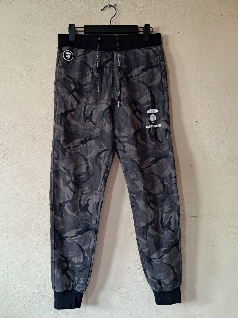 AAPE BY A BATHING APE Camo Jogger Pants (Category: Joggers) located in Silang. Submitted by segundalifestyle (Listing ID 1443265243, Image 1). Description: - Camo joggers from AAPE BY A BATHING APE - Signature ape head logo on left leg - Smaller logo detail on right pocket - removable patch logo - Drawstring waist for adjustable fit - Elasticated cuffs - Ideal for casual wear - waist 26 - Length 37.