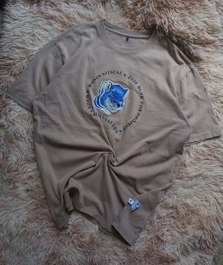 ADER error x Maison Kitsuné Blue Fox Project T-shirt (Category: Tshirts & Polo Shirts ) located in Boston. Submitted by johnpaulvi30029 (Listing ID 1443224831, Image 2). Description: - ADER error x Maison Kitsuné collaboration tee - Features the Blue Fox Project graphic - Neutral beige color - Perfect for casual outfits.