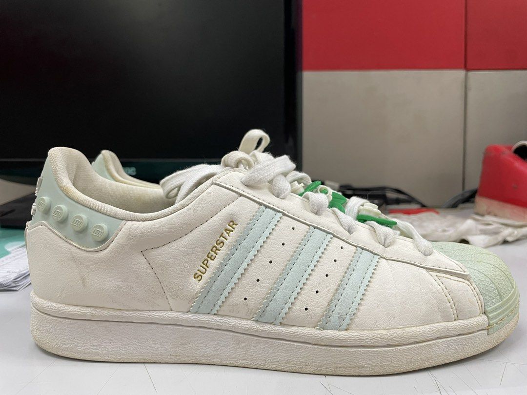 Adidas Superstar x LEGO Shoes (Category: Sneakers) located in Manila. Submitted by _maryan.marcial (Listing ID 1443141997, Image 2). Description: - Clear White Ice Mint Adidas Superstar sneakers - US Women's Size 7 - Light blue accents - Fun LEGO brick detail on the heel - Cute flower lace charms - LEGO logo on the tongue - Made in Indonesia.