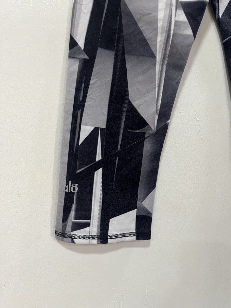 Alo Yoga Geometric Print Capris Leggings Size S (Category: Activewear) located in Baliuag. Submitted by TOCThrift (Listing ID 1443285924, Image 3). Description: - Brand: Alo Yoga - Style: Capri Leggings - Size: S - Design: Cool geometric print in black, white, and grey - Material: Stretchy for comfort - Versatile: Perfect for workouts or casual wear.