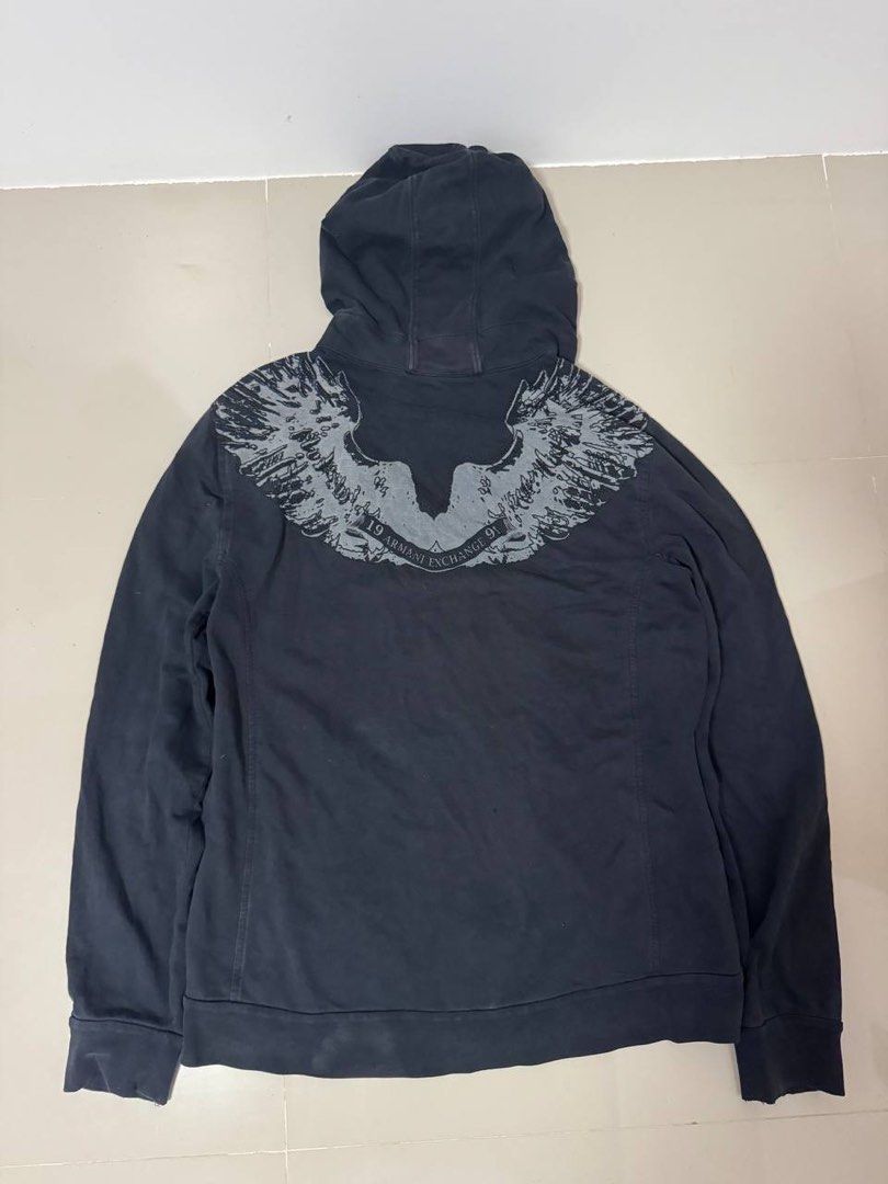 Armani Exchange Zip-Up Hoodie with Eagle Graphic (Category: Coats, Jackets and Outerwear) located in Lupi. Submitted by shittynappy (Listing ID 1443248971, Image 3). Description: 📍 PM for Infos PSG ko😞 - Armani Exchange zip-up hoodie - Size: Medium (M) - Features a cool eagle wing graphic on the back - Smaller graphic details on the front - Smooth zip-up closure - Drawstring hood for adjustable comfort - Comfortable material, perfect for casual