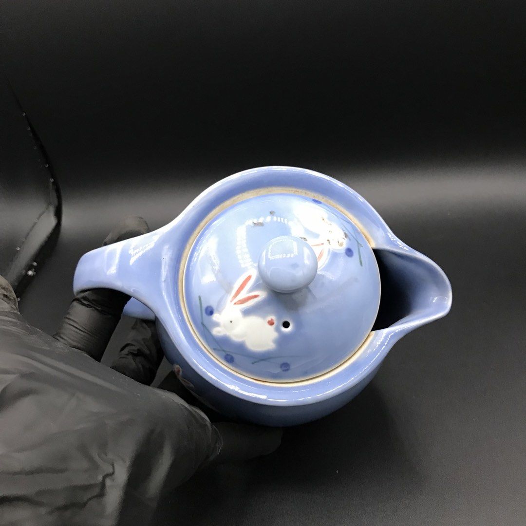 Blue Ceramic Teapot with Bunny Design (Category: Coffee & Tea Tableware) located in Baao. Submitted by all.things.japan (Listing ID 1443134513, Image 3). Description: - Adorable blue ceramic teapot - Features charming white bunnies and blue dots all over - Comes with a comfortable handle - Includes a lid with a small knob for easy pouring - Perfect for serving your favorite teas - Makes a wonderful gift for tea lovers or a lovely decorative accen