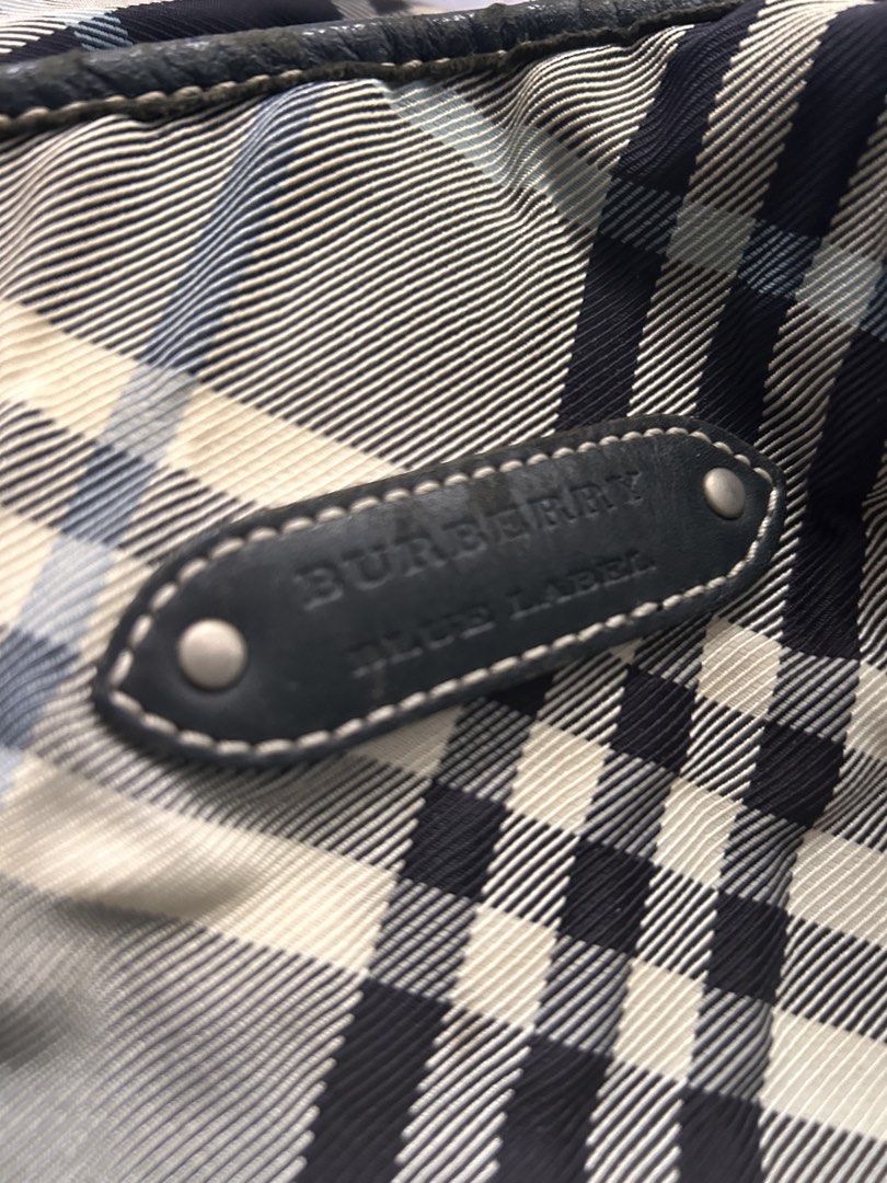 Burberry Bag (Category: Bags & Wallets) located in Singapore. Submitted by xoxo_elis (Listing ID 1443171663, Image 2). Description: - Authentic Burberry Blue Label tote - Iconic plaid pattern - Genuine leather trim and handles - Secure zipper closure - Convenient interior pocket - Spacious for everyday essentials - Rarely used; the back of bag is such due to storage - Comes as it is.