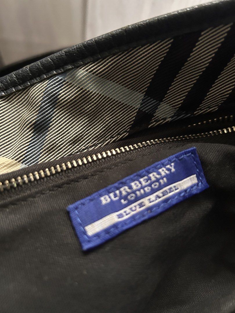 Burberry Bag (Category: Bags & Wallets) located in Singapore. Submitted by xoxo_elis (Listing ID 1443171663, Image 3). Description: - Authentic Burberry Blue Label tote - Iconic plaid pattern - Genuine leather trim and handles - Secure zipper closure - Convenient interior pocket - Spacious for everyday essentials - Rarely used; the back of bag is such due to storage - Comes as it is.