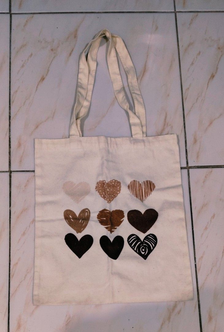 Canvas Tote Bag with Heart Print (Category: Tote Bags) located in Rizal. Submitted by reese511 (Listing ID 1443137547, Image 1). Description: Declutter - Cream colored canvas tote bag - Features a cute print of nine hearts in various shades of brown and rose gold - Handles made of the same canvas material - Ideal for everyday use, shopping, or carrying essentials - Simple and stylish design.