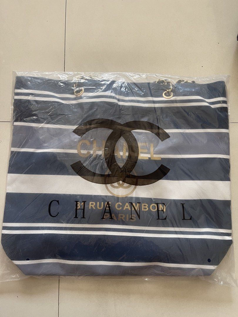 Chanel Striped Tote Bag (Category: Luxury Bags & Wallets) located in Quezon City. Submitted by kingcurator (Listing ID 1443209080, Image 2). Description: - Classic Chanel tote bag - Horizontal stripes in navy, grey, and white - Gold 'CHANEL' logo and '31 RUE CAMBON PARIS' text - Elegant chain detail on handles - Spacious interior for all your essentials - Ideal for everyday use or travel.