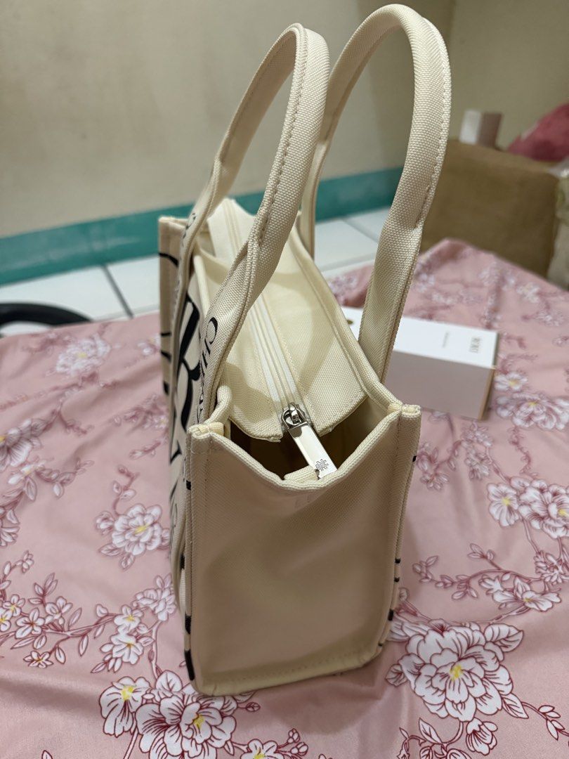 Christy Ng Canvas Mini Tote Bag (Category: Tote Bags) located in Manila. Submitted by lifeofchamppreloved (Listing ID 1443160532, Image 2). Description: Cristy Ng mini print tote bag. - Used once - With paper bag - Cream canvas tote bag - Zipper closure - Ideal for everyday use.