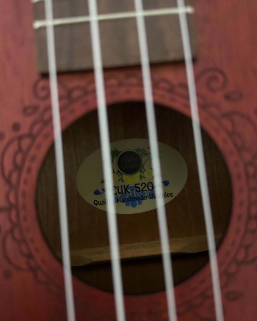 Clifton CUK-520 Concert Ukulele (Category: Musical Instruments) located in Manila. Submitted by shop.anika (Listing ID 1443229769, Image 3). Description: • Selling my Clifton CUK-520 concert ukulele, featuring a mahogany body with a matte red finish and laser-engraved rosette details. • The instrument is 23 inches long and includes a padded gig bag for transport. • It is equipped with rosewood for the fingerboard and bridge, and is designed for b