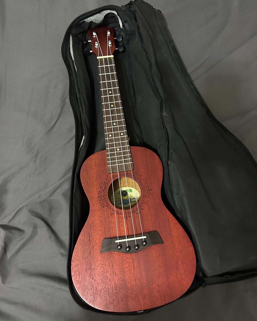 Clifton CUK-520 Concert Ukulele (Category: Musical Instruments) located in Manila. Submitted by shop.anika (Listing ID 1443229769, Image 2). Description: • Selling my Clifton CUK-520 concert ukulele, featuring a mahogany body with a matte red finish and laser-engraved rosette details. • The instrument is 23 inches long and includes a padded gig bag for transport. • It is equipped with rosewood for the fingerboard and bridge, and is designed for b