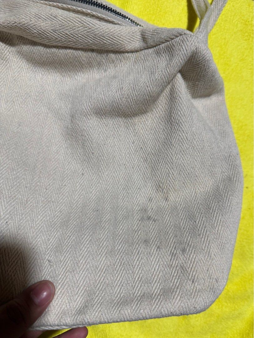 Cream Canvas Shoulder Bag with Zipper (Category: Shoulder Bags) located in Taytay. Submitted by jayezapanta (Listing ID 1443296058, Image 2). Description: - Cream colored canvas shoulder bag - Unique herringbone weave pattern - Secure zipper closure for main compartment - Adjustable strap with stylish metal eyelets - Minor faint marks on exterior fabric - Interior lining shows some staining and fraying near the top seam - A practical and versatil