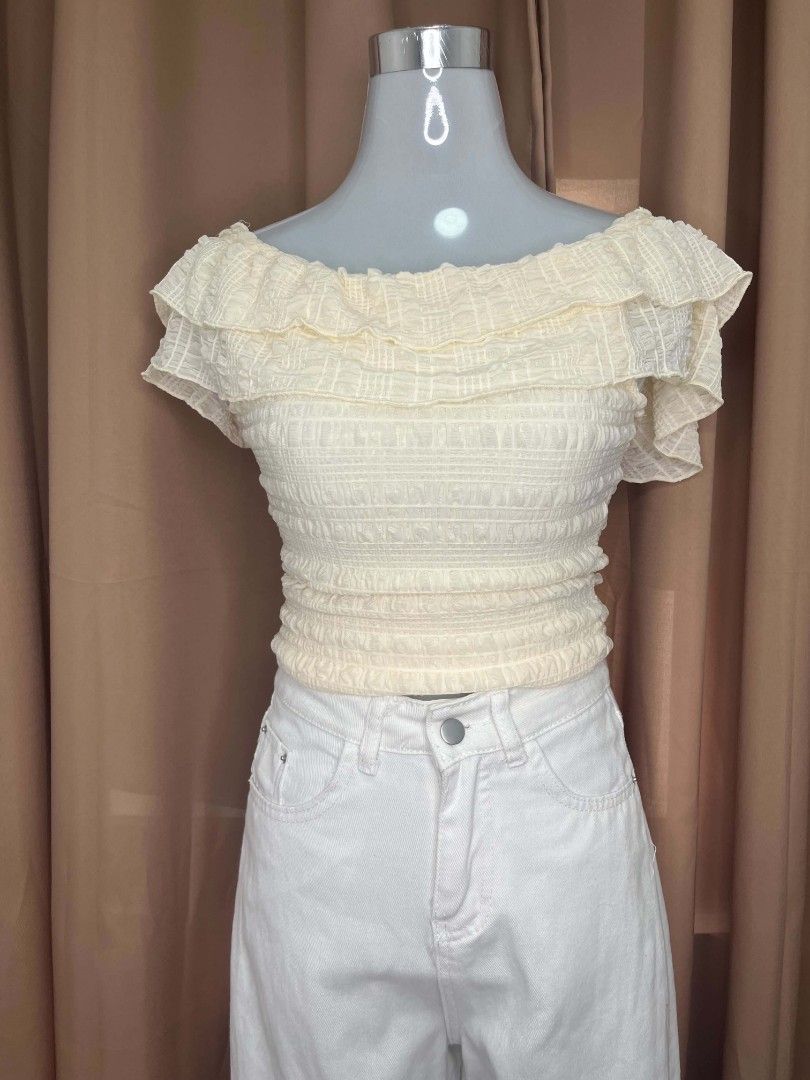 Cream Off-Shoulder Smocked Ruffle Crop Top (Category: Others Tops) located in Manila. Submitted by moon.sage (Listing ID 1443196604, Image 1). Description: - Cute cream off-shoulder top - Smocked body for a flattering fit - Ruffle details on neckline and sleeves - Adjustable tie-back detail - Very stretchy and comfortable material - Pairs perfectly with high-waisted jeans or skirts.