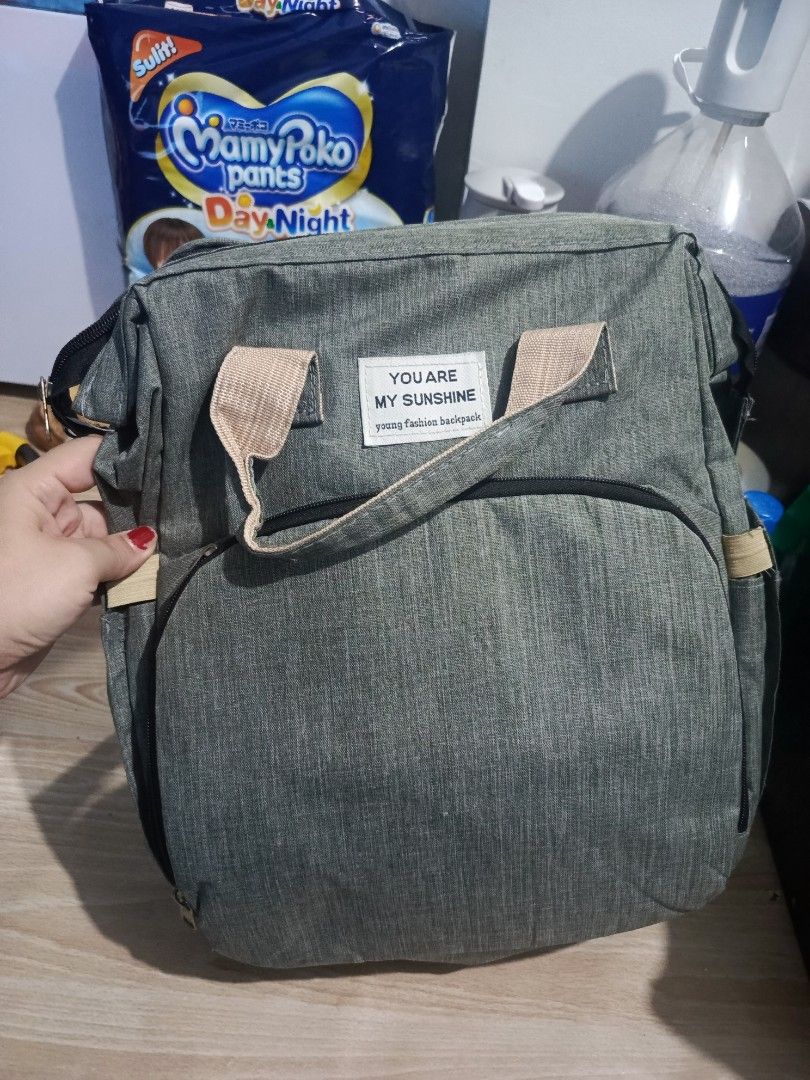 Grey Diaper Bag Backpack "You Are My Sunshine" (Category: Backpacks) located in Manila. Submitted by isharishni33773 (Listing ID 1443220839, Image 1). Description: - Stylish grey diaper bag backpack with 'You Are My Sunshine' print. - Multiple straps and pockets for excellent organization of baby essentials. - Comfortable to wear as a backpack. - Made with durable material for long-lasting use. Rfs: twice lang nagamit.