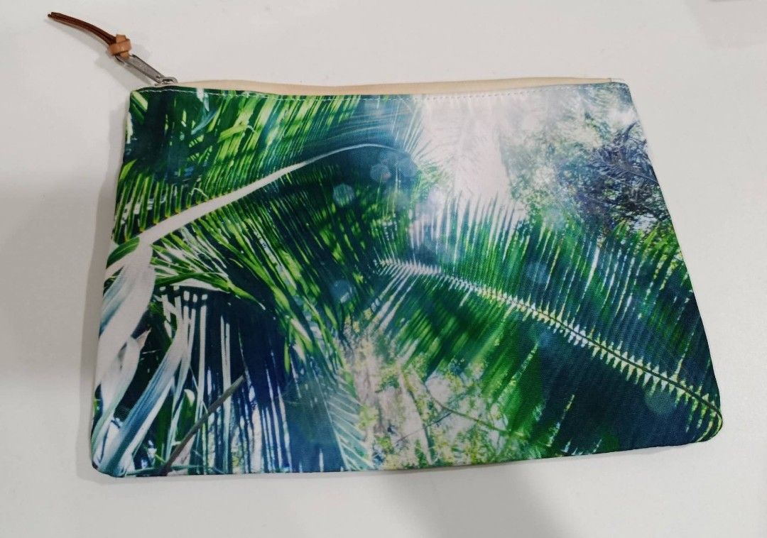 Herschel Supply Co. Tropical Print Pouch (Category: Purses & Pouches) located in Baguio. Submitted by gabierfinds (Listing ID 1443313877, Image 1). Description: Cool Herschel pouch with a tropical palm leaf print on one side and a beach scene on the other. The inside has a red and white striped lining. Has a leather pull tab and a metal zipper. Great for organizing your essentials..