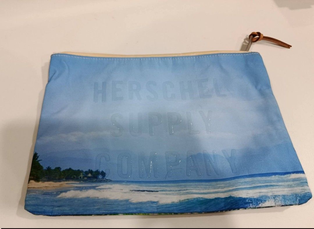 Herschel Supply Co. Tropical Print Pouch (Category: Purses & Pouches) located in Baguio. Submitted by gabierfinds (Listing ID 1443313877, Image 2). Description: Cool Herschel pouch with a tropical palm leaf print on one side and a beach scene on the other. The inside has a red and white striped lining. Has a leather pull tab and a metal zipper. Great for organizing your essentials..