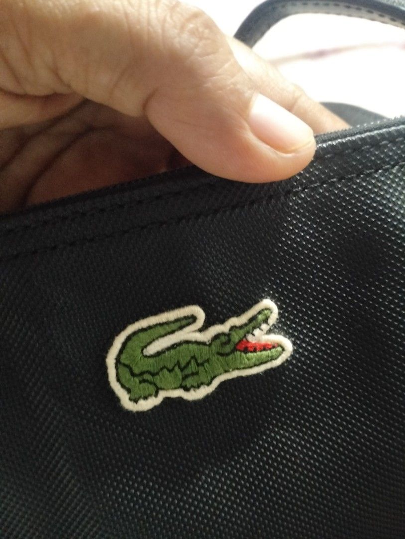 Lacoste Black Nylon Tote Bag (Category: Tote Bags) located in Talibon. Submitted by saysonlest75795 (Listing ID 1443266986, Image 3). Description: - Classic black Lacoste tote bag - Iconic green crocodile logo on front - Secure zip closure - Spacious interior for essentials - Ideal for everyday use or travel - excellent condition - issue sign of usage sa Handle - check Pic.