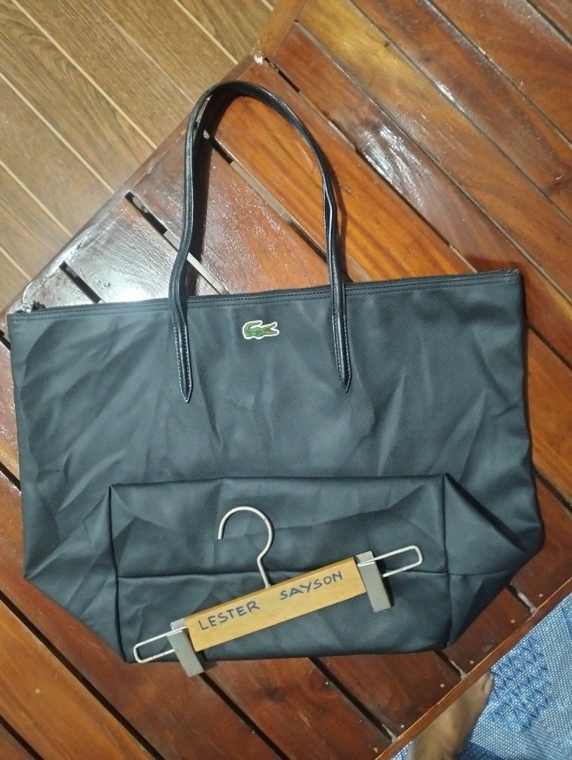 Lacoste Black Nylon Tote Bag (Category: Tote Bags) located in Talibon. Submitted by saysonlest75795 (Listing ID 1443266986, Image 2). Description: - Classic black Lacoste tote bag - Iconic green crocodile logo on front - Secure zip closure - Spacious interior for essentials - Ideal for everyday use or travel - excellent condition - issue sign of usage sa Handle - check Pic.