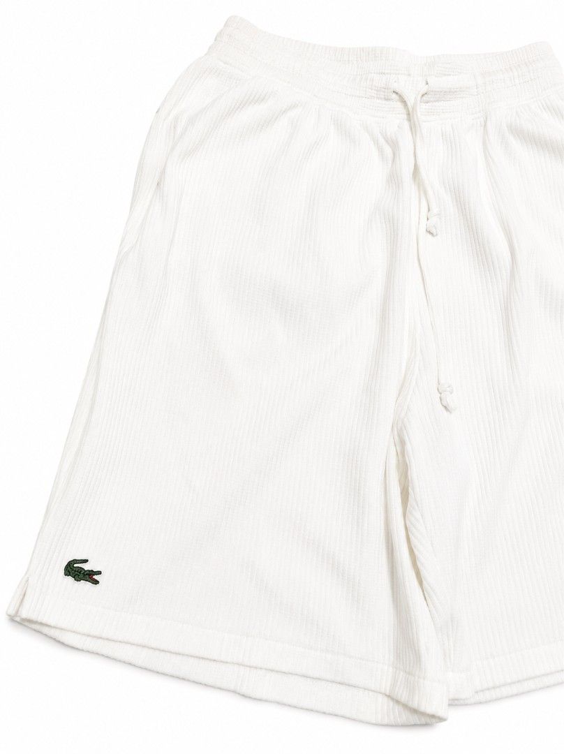 Lacoste White Corduroy Shorts (Category: Shorts) located in Vallehermoso. Submitted by threy (Listing ID 1443239869, Image 1). Description: - White corduroy shorts from Lacoste - Features the iconic crocodile logo on the left leg - Elastic waistband with drawstring for a comfortable fit - Ideal for casual wear or lounging - Simple and classic design.