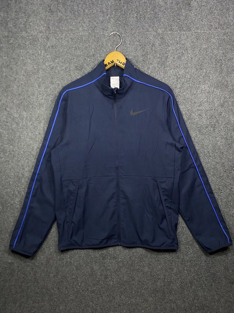 Nike Dri-FIT Navy Blue Track Jacket Size M (Category: Coats, Jackets and Outerwear) located in Bolinao. Submitted by frenced28 (Listing ID 1443263267, Image 1). Description: Wide:21 length:27 - Navy blue Nike Dri-FIT track jacket - Blue piping along shoulders and sleeves - Nike logo on chest - Made in China - Size: Medium (M).