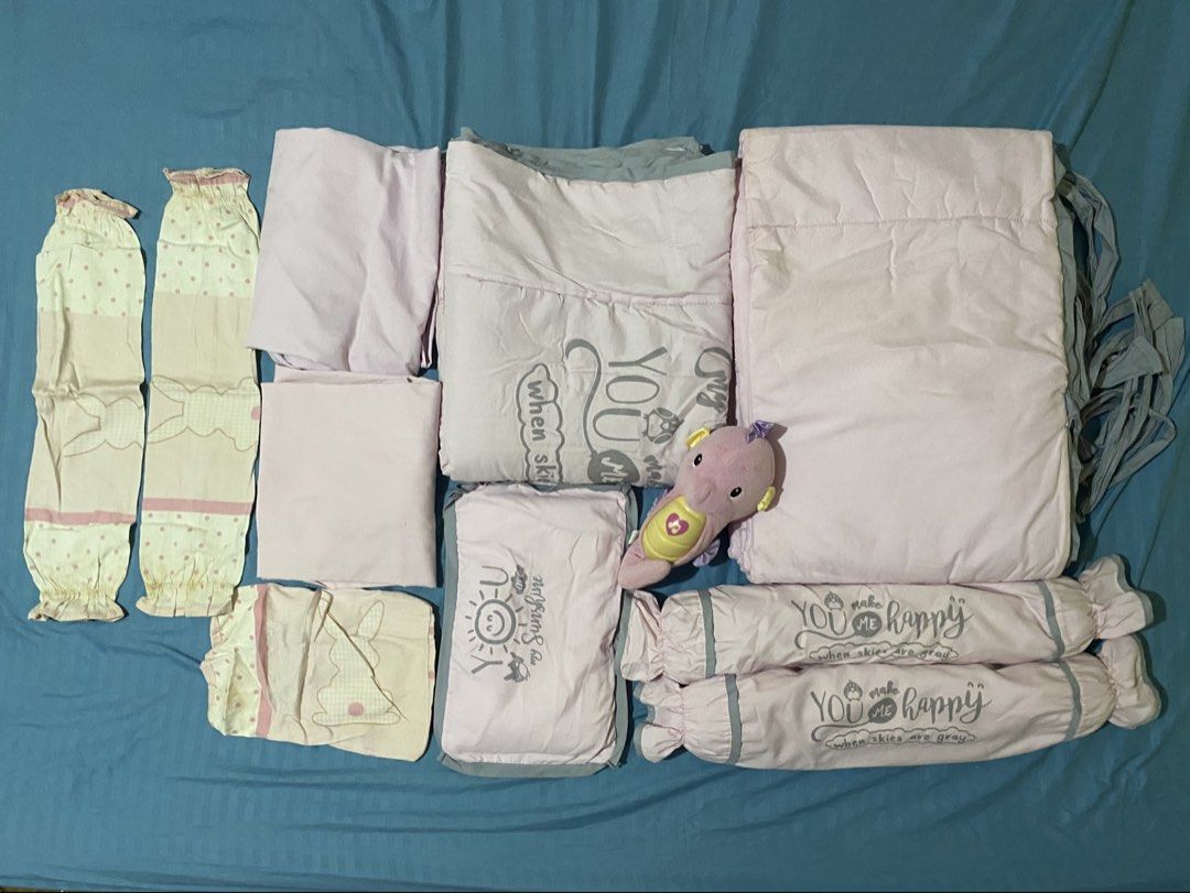 Pink Baby Bedding Set with Plush Toy (Category: Cots & Cribs) located in Binan City. Submitted by prelovedlagunaph (Listing ID 1443272887, Image 1). Description: - Complete pink baby bedding set - Includes: fitted sheet, duvet cover, pillowcases, bumper rolls - Adorable plush toy included - Features cute cloud and bunny prints - Bumper rolls have 'You make me happy' text - Ideal for a baby's crib.