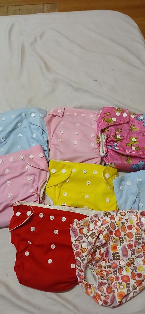 Reusable Cloth Diapers - Various Colors and Prints (Category: Diapers & Baby Wipes) located in Caloocan City. Submitted by nathangrac08592 (Listing ID 1443313367, Image 1). Description: - Bundle of cloth diapers - Includes solid colors (pink, blue, yellow) and fun prints - Adjustable snaps for a customizable fit - Eco-conscious choice for parents - Comes with a red diaper cover.
